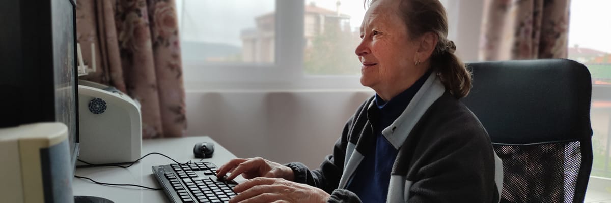 Elderly lady using her computer to research care funding