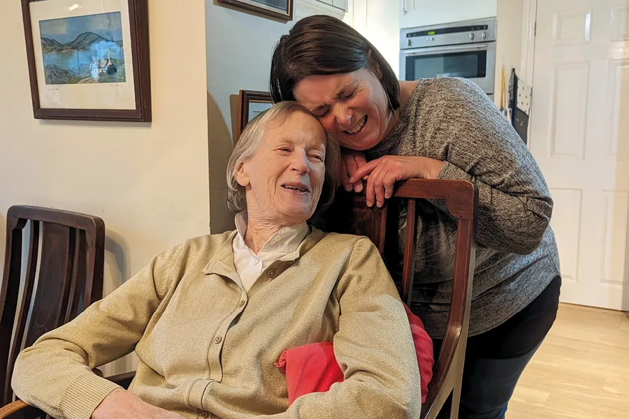 Elderly female client and her caregiver laughing