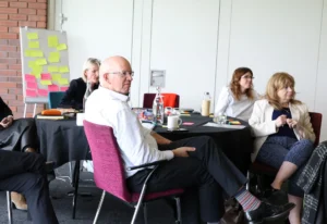 A table of attendees at our leadership conference listening to one of the sessions