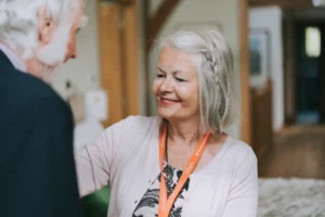 A smiley carer helping her client