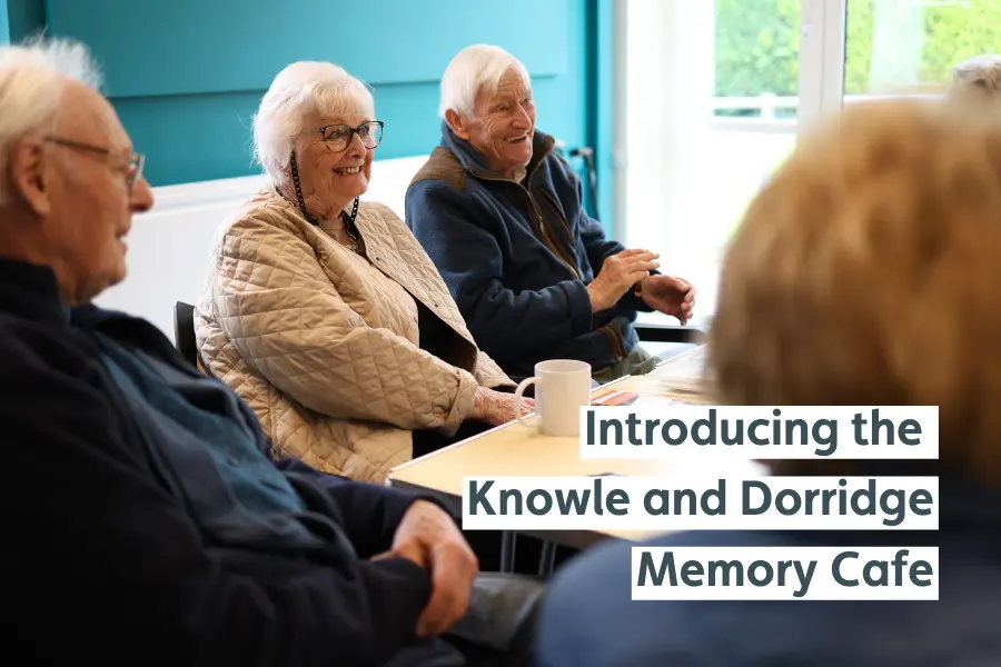 Attendees at the launch of the Knowle and Dorridge Memory cafe sat at a table laughing, with the text 'Introducing the knowle and dorridge memory cafe'