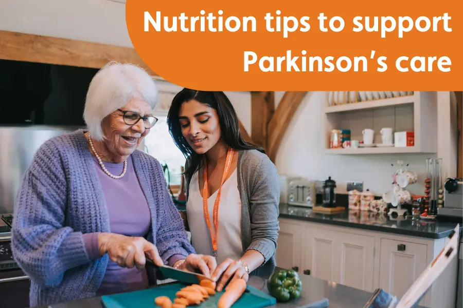 An older woman with Parkinson's chopping carrots alongside a caregiver in a kitchen, promoting nutrition tips for Parkinson's care.